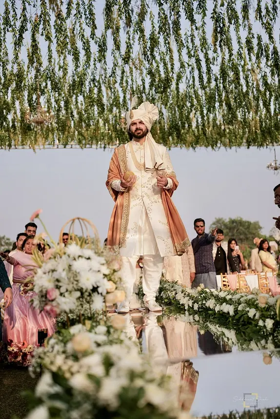 Groom on stage under a floral canopy