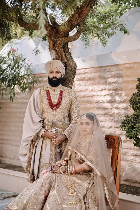 Couple under a tree beside a stone wall